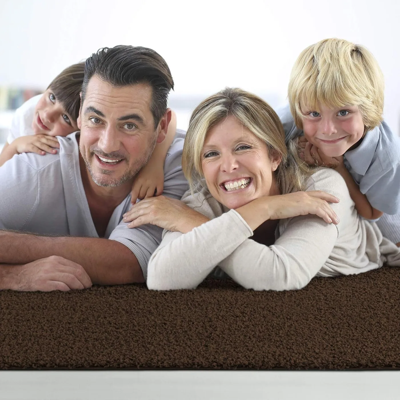 Familie auf einem braunen Impression Shaggy-Teppich